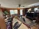 Cozy living room featuring wood-paneled walls, comfortable seating, and a ceiling fan for a relaxed atmosphere at 18401 Hamilton Rd, Dade City, FL 33523