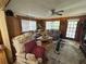 Cozy living room featuring wood-paneled walls, comfortable seating, and a ceiling fan for a relaxed atmosphere at 18401 Hamilton Rd, Dade City, FL 33523