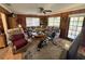 Cozy living room featuring wood-paneled walls, comfortable seating, and a ceiling fan for a relaxed atmosphere at 18401 Hamilton Rd, Dade City, FL 33523