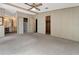 Spacious main bedroom featuring carpet floors, a ceiling fan, two closets, and an ensuite bathroom at 228 N Saint George Cir, Apollo Beach, FL 33572