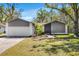 Charming single-story home featuring a well-manicured lawn, attached garage and beautifully landscaped front yard at 2425 Blind Pond Ave, Lutz, FL 33549