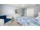 Comfortable bedroom featuring a blue patchwork quilt, white dresser and blue accent chair at 280 Dr Ml King Jr N St, Safety Harbor, FL 34695