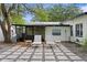 Well-maintained backyard featuring a paved patio with lounge chairs, grill, and an enclosed patio area at 2912 W Winthrop Rd, Tampa, FL 33611
