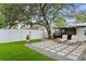 Lush backyard with green lawn, paved patio, lounge chairs, and a built-in grill at 2912 W Winthrop Rd, Tampa, FL 33611