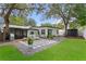 Expansive backyard featuring green lawn, lounge chairs, grill area, and an enclosed patio at 2912 W Winthrop Rd, Tampa, FL 33611