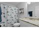 A bathroom with a granite countertop sink, white tiling, and a themed shower curtain at 2912 W Winthrop Rd, Tampa, FL 33611