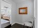 Light and airy bedroom entrance with wooden mirror and chair on dark wood flooring at 2912 W Winthrop Rd, Tampa, FL 33611
