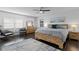 Bright bedroom featuring a ceiling fan, artwork, dark floors and a wood bed frame at 2912 W Winthrop Rd, Tampa, FL 33611