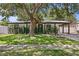 Charming single-story home with lush landscaping and a welcoming front entrance and covered parking at 2912 W Winthrop Rd, Tampa, FL 33611