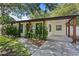 Charming single-story home with lush landscaping and a welcoming front entrance and covered parking at 2912 W Winthrop Rd, Tampa, FL 33611