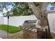A stainless steel grill sits near a large tree in the backyard at 2912 W Winthrop Rd, Tampa, FL 33611