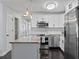 Spacious kitchen with an island, stainless steel appliances, white cabinets, and modern pendant lighting at 2912 W Winthrop Rd, Tampa, FL 33611