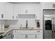 Bright kitchen showcasing white cabinets, granite countertops, stainless steel fridge, and a sleek sink at 2912 W Winthrop Rd, Tampa, FL 33611