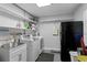 Functional laundry room with modern washer and dryer, ample shelving, and a utility sink at 2912 W Winthrop Rd, Tampa, FL 33611