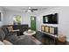Cozy living room featuring dark wood floors, recessed lighting, fan and large sectional couch at 2912 W Winthrop Rd, Tampa, FL 33611