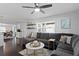 Spacious living room featuring dark wood floors, recessed lighting, fan and large sectional couch at 2912 W Winthrop Rd, Tampa, FL 33611