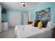 Stylish bedroom featuring blue walls, plush bedding, and a vibrant art piece, creating a cozy and inviting atmosphere at 2915 67Th Way N, St Petersburg, FL 33710
