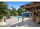 Inviting backyard pool area with a tiki bar, lounge chairs, lush landscaping and covered deck at 2915 67Th Way N, St Petersburg, FL 33710