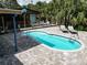 A tranquil pool area with a custom bar, surrounded by lush greenery, and inviting lounge chairs for ultimate relaxation at 2915 67Th Way N, St Petersburg, FL 33710