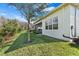 This home features a meticulously maintained lawn, mature tree, and a screened in porch for outdoor living at 31046 Lindentree Dr, Wesley Chapel, FL 33543