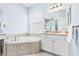 Bright bathroom featuring a soaker tub, separate vanity and tile flooring at 31046 Lindentree Dr, Wesley Chapel, FL 33543