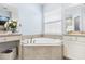 A spa-like bathroom features a tub, built in vanity and quartz countertops at 31046 Lindentree Dr, Wesley Chapel, FL 33543