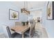 Dining area adjacent to kitchen, featuring modern light fixture and artwork at 31046 Lindentree Dr, Wesley Chapel, FL 33543