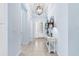Bright entryway with a view of the front door, decorated with a stylish table and modern lighting at 31046 Lindentree Dr, Wesley Chapel, FL 33543
