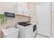 Well-equipped laundry room with modern washer, dryer, sink, and storage cabinets for efficient home management at 31046 Lindentree Dr, Wesley Chapel, FL 33543
