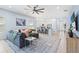 Bright open concept living room with tile floors, ceiling fan, and connected kitchen and breakfast bar at 31046 Lindentree Dr, Wesley Chapel, FL 33543