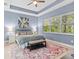 A spacious main bedroom features a tray ceiling, neutral walls, tile flooring, and natural light at 31046 Lindentree Dr, Wesley Chapel, FL 33543