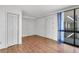 Bedroom with wood flooring, closet, and large window with sheer curtains at 3301 Bayshore Blvd # 2007B, Tampa, FL 33629