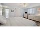 Bright bedroom featuring blue walls, wood floors, a ceiling fan, and a bathroom en suite at 3307 Maitland Dr, Holiday, FL 34691