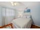Relaxing bedroom featuring blue walls, hardwood floors, a ceiling fan, and an inviting bed at 3307 Maitland Dr, Holiday, FL 34691
