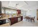 Kitchen and dining area, featuring brown cabinets, stainless appliances and tile floor at 3307 Maitland Dr, Holiday, FL 34691