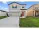 Attractive home with a two-car garage, manicured lawn, and inviting covered entrance at 35138 Daisy Meadow Loop, Zephyrhills, FL 33541