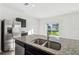 Kitchen island with a double sink, granite countertops, and stainless steel refrigerator at 35138 Daisy Meadow Loop, Zephyrhills, FL 33541