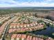 Aerial view of a community with red tile roofs, multiple ponds, and lush landscaping at 3876 Timber Ridge Ct, Palm Harbor, FL 34685