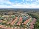 Aerial view showing a community with tile roofs, beautiful landscaping, and ponds at 3876 Timber Ridge Ct, Palm Harbor, FL 34685