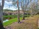 Lush backyard with mature trees, water views, and a glimpse of the home's exterior at 3876 Timber Ridge Ct, Palm Harbor, FL 34685