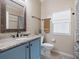 Bathroom featuring a blue vanity with a marble countertop, wooden framed mirror, and bronze fixtures at 3876 Timber Ridge Ct, Palm Harbor, FL 34685