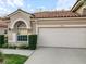 Front view of a home featuring a two-car garage and manicured landscaping at 3876 Timber Ridge Ct, Palm Harbor, FL 34685