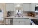 Bright kitchen featuring modern sink, stainless steel dishwasher, and light blue cabinets at 3876 Timber Ridge Ct, Palm Harbor, FL 34685