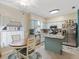 Bright kitchen and breakfast nook featuring stainless steel appliances, blue island, and blue kitchen cabinets at 3876 Timber Ridge Ct, Palm Harbor, FL 34685