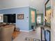 Entry to a cozy living room featuring blue walls, wood floors, and a glimpse into the dining area at 3876 Timber Ridge Ct, Palm Harbor, FL 34685