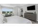 Bedroom with a flat screen TV and dresser, with ensuite bathroom and views through a large window at 4043 Rocky Shores Dr, Tampa, FL 33634
