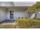 A covered entrance features a gray door, brick pavers and landscaped shrubs at 4043 Rocky Shores Dr, Tampa, FL 33634