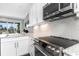 This modern kitchen features white cabinets, stainless steel appliances, and a door leading to a balcony at 4043 Rocky Shores Dr, Tampa, FL 33634