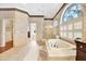 Bathroom with a large tub, glass shower, tile floors, and neutral paint at 407 S West Shore Blvd, Tampa, FL 33609
