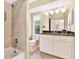 Bathroom featuring white vanity, a tub with a shower, and a window at 407 S West Shore Blvd, Tampa, FL 33609